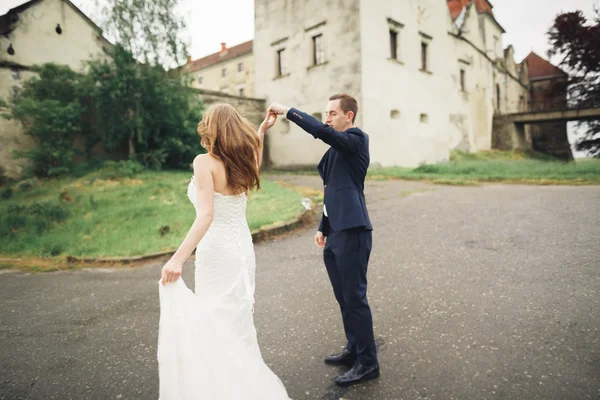 Piękny romantyczny ślub para nowożeńców przytulających się w pobliżu starego zamku — Zdjęcie stockowe