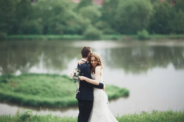 Romantické svatební pár, muž a žena, představuje v blízkosti krásného jezera — Stock fotografie