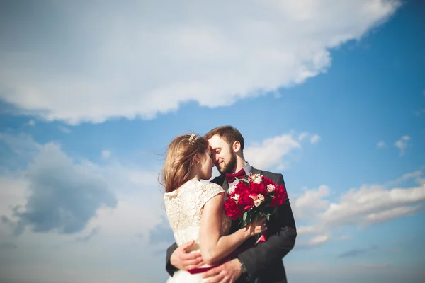 Casada pareja de boda de pie en un muelle sobre el mar —  Fotos de Stock