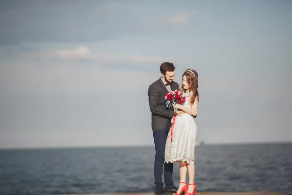 Couple marié debout sur un quai au-dessus de la mer — Photo