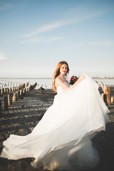 ブライダル ブーケの背景海でポーズ美しい若い花嫁 — ストック写真