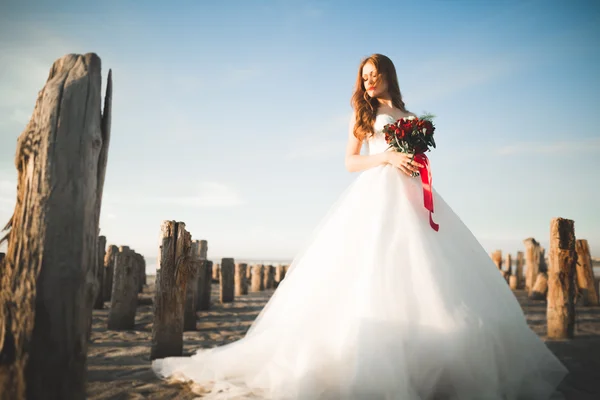 ブライダル ブーケの背景海でポーズ美しい若い花嫁 — ストック写真