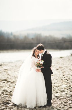 Mutlu evlilik çift, gelin ve damat zemin Dağları nın karşı temiz nehir poz