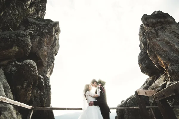 Pareja feliz boda, novia y novio posando cerca de rocas con hermosas vistas —  Fotos de Stock