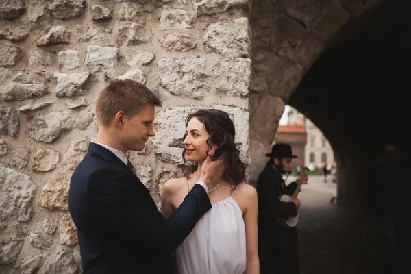 Hochzeitspaar, Braut, Bräutigam küssen und umarmen sich an der Wand — Stockfoto