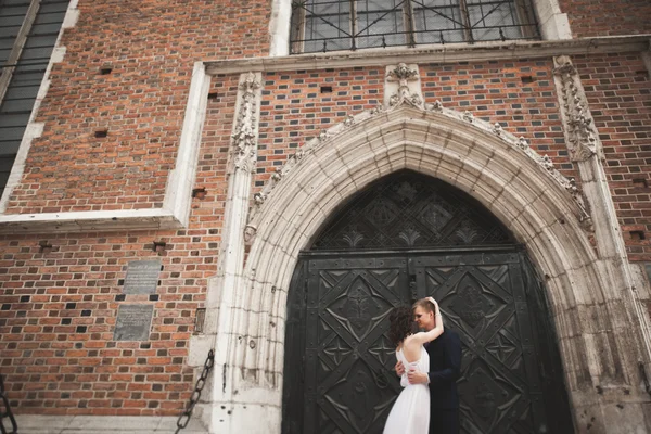 Splendida coppia di nozze, sposa, sposo posa vicino vecchio edificio cancello — Foto Stock