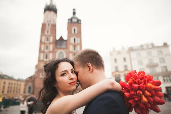 Elegante schöne Hochzeitspaar zu Fuß auf dem Hauptplatz in Krakau — Stockfoto