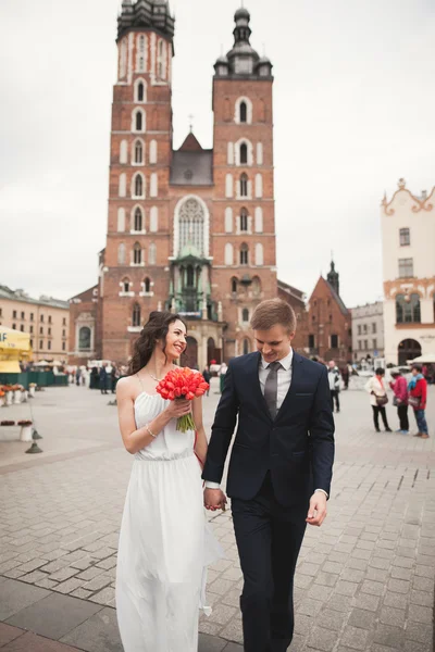 优雅的美丽婚礼夫妇在克拉科夫的主要广场上散步 — 图库照片