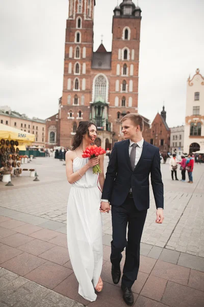 优雅的美丽婚礼夫妇在克拉科夫的主要广场上散步 — 图库照片