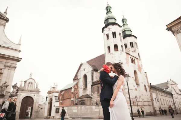 新娘和新郎背景下的美丽的教堂。漂亮的旧建筑。建筑学的婚礼 — 图库照片