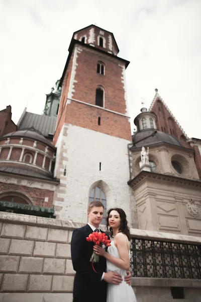 Hochzeitspaar, Brautpaar beim Spaziergang in der Nähe einer Kirche in Krakau — Stockfoto