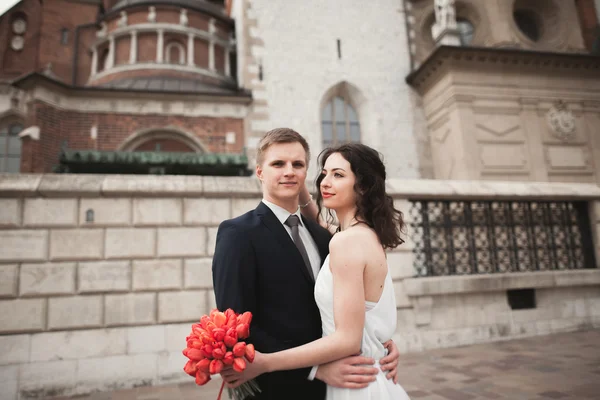 Hochzeitspaar, Brautpaar beim Spaziergang in der Nähe einer Kirche in Krakau — Stockfoto