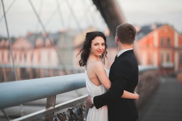 Smukke bryllup par, brud og brudgom poserende på broen i Krakow - Stock-foto