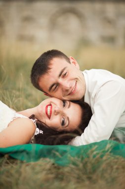 Mutlu evlilik çift yaz saati, yeşil çim üzerinde yalan