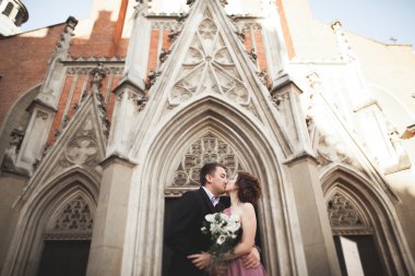 Yanında bir kilise poz zarif güzel düğün çifti. Krakow