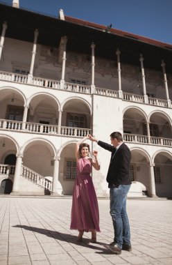 Mutlu düğün çift, damat, Gelin pembe elbise ile sarılma ve birbirlerine arka plan üzerinde gülümseyen duvarlar kalede