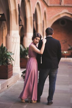 Genç çift aşk gelin ve damat ve arka plan üzerinde beyaz sütun içeren alan yakın poz. Krakow