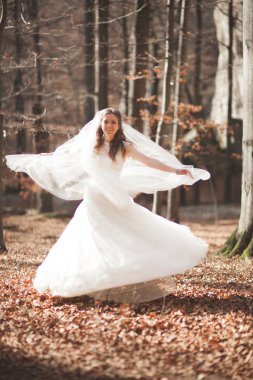 Buket tutarak ve orman poz şık elbiseli güzel gelin