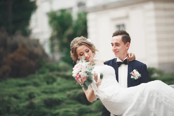 Wedding couple is standing and kissing in the streets of old city — Stock Photo, Image