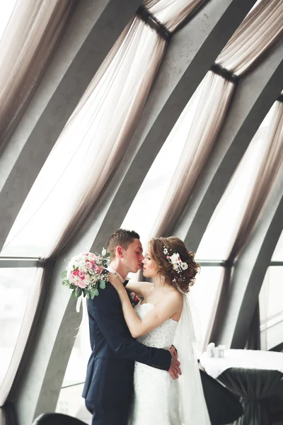 Casamento casal está de pé e beijando no hotel — Fotografia de Stock