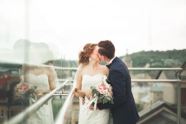 Glückliches Hochzeitspaar, Braut, Bräutigam küssen sich mit Blick auf die Altstadt — Stockfoto