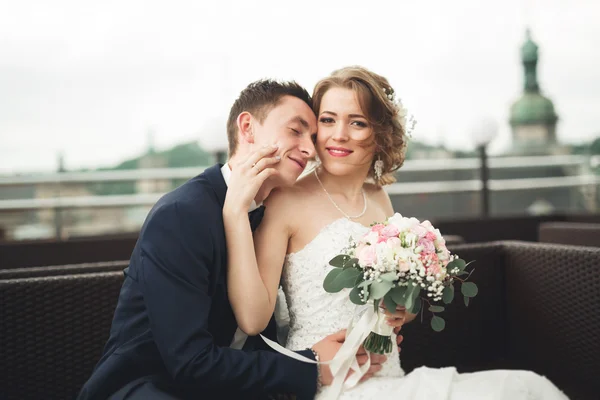 Glückliches Hochzeitspaar, Braut, Bräutigam küssen sich mit Blick auf die Altstadt — Stockfoto