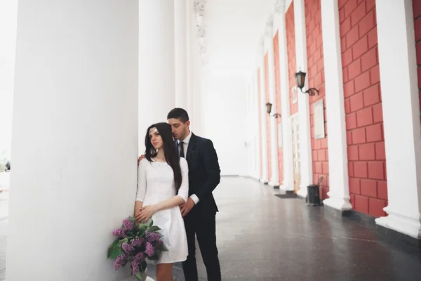 Όμορφο ζευγάρι, νύφη και ο γαμπρός που παρουσιάζουν κοντά μεγάλο λευκό στήλη — Φωτογραφία Αρχείου