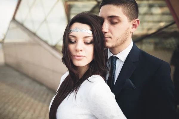 Elegante hermosa pareja posando cerca de edificio de vidrio moderno —  Fotos de Stock