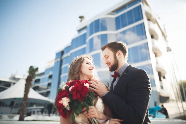 Eleganta vackra par poserar nära moderna glasbyggnad — Stockfoto