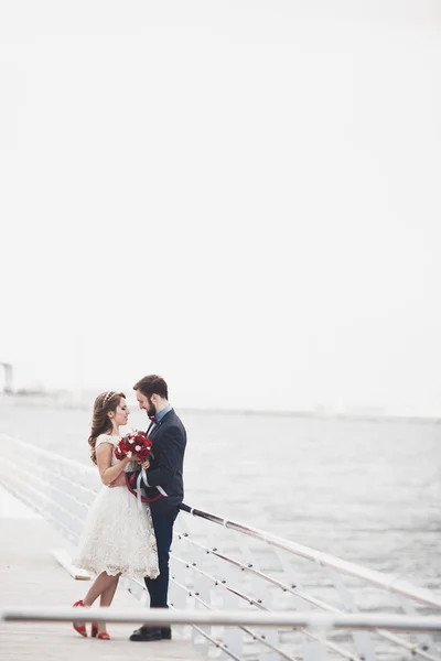 夕暮れ時のビーチを歩いてちょうど結婚して結婚式のカップル. — ストック写真