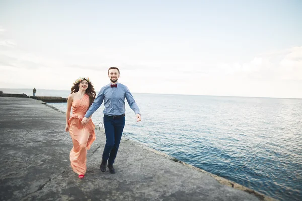 Krásnou milující pár, pýcha s dlouhé šaty, chůzi po molu — Stock fotografie