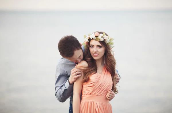 Hochzeitspaar steht auf einem Kai über dem Meer — Stockfoto