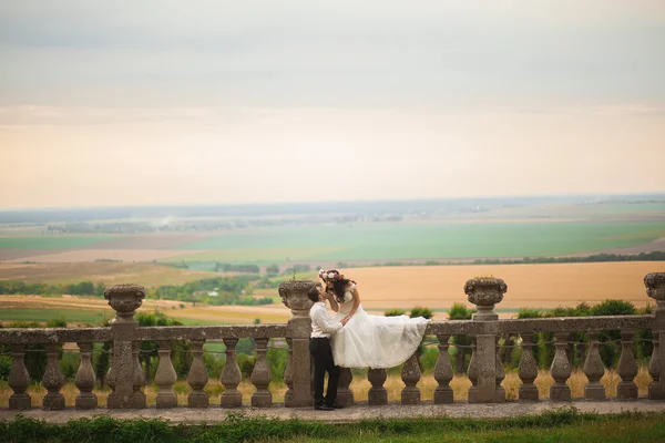 Feliz casamento casal abraçando e beijando no fundo velho castelo — Fotografia de Stock