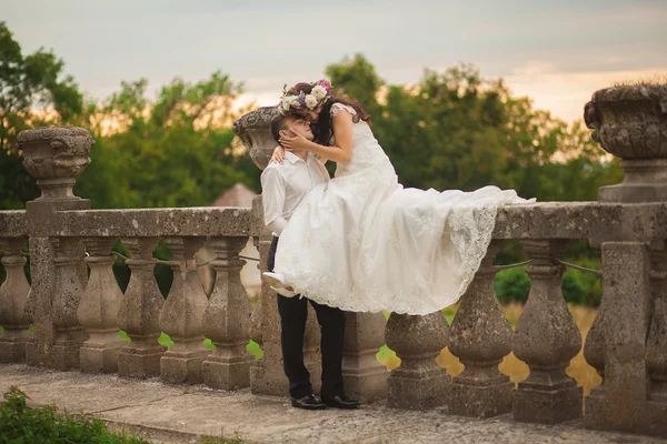 Beautiful romantic wedding couple of newlyweds hugging near old castle — Stock Photo, Image