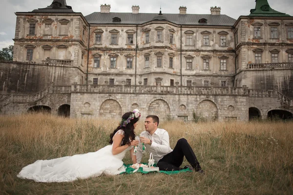Felice matrimonio coppia abbracciare e baciare su sfondo vecchio castello — Foto Stock