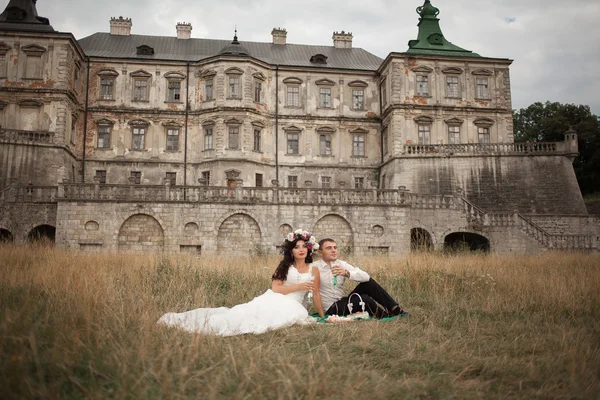 Feliz boda pareja abrazos y besos en el fondo viejo castillo — Foto de Stock