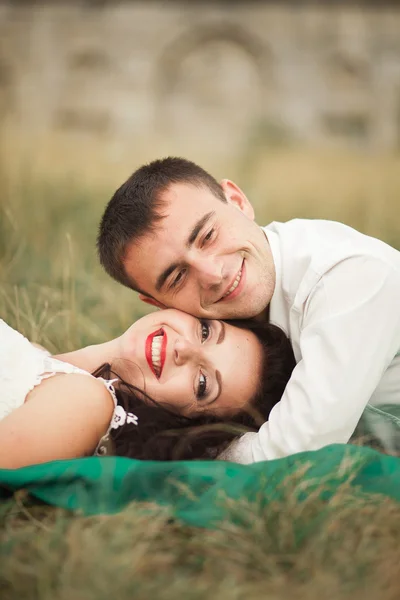 여름 시간에 푸른 잔디에 누워 행복 한 웨딩 커플 — 스톡 사진