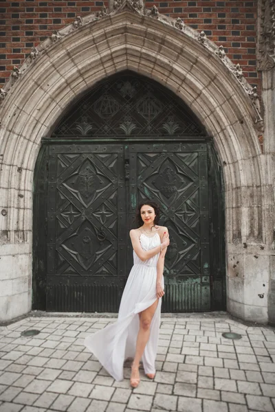 Krásná mladá nevěsta pózuje na pozadí stará budova — Stock fotografie