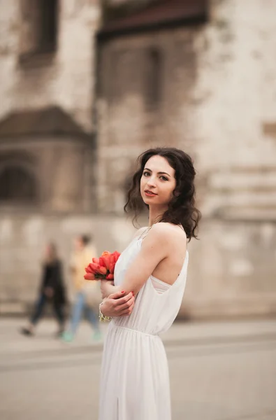 Красивая молодая невеста с свадебным букетом на заднем плане церкви — стоковое фото