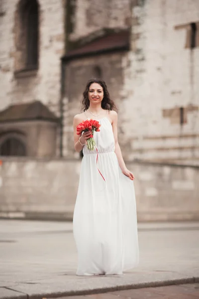Красивая молодая невеста с свадебным букетом на заднем плане церкви — стоковое фото