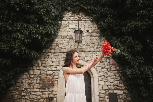 Mariée. Belle jeune femme dans le parc avec bouquet par une chaude journée d'été . — Photo