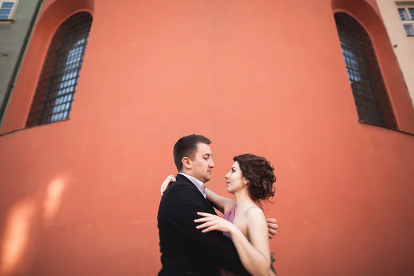 Casal lindo casamento, noivo e noiva com vestido rosa andando na cidade velha de Cracóvia — Fotografia de Stock
