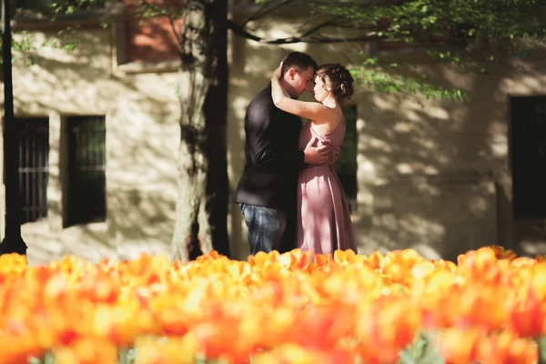Молодая супружеская пара позирует возле дерева с цветами — стоковое фото