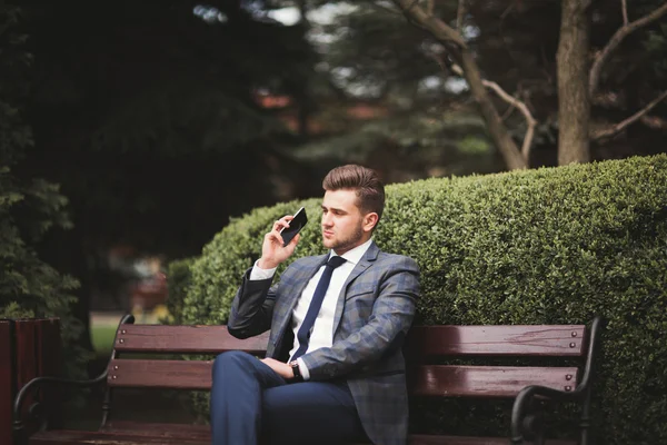 Elegante joven hombre de negocios hablando por teléfono al aire libre —  Fotos de Stock