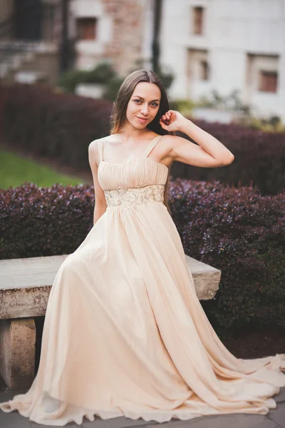 Schöne glückliche Frau im Park an einem warmen Frühlingstag auf der Bank sitzend — Stockfoto