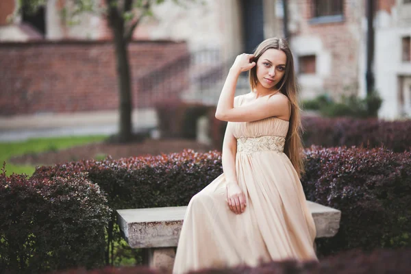 Schöne glückliche Frau im Park an einem warmen Frühlingstag auf der Bank sitzend — Stockfoto