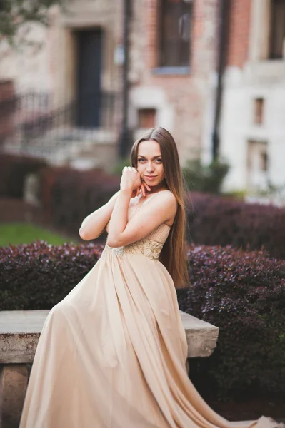 Bella donna felice nel parco una calda giornata di primavera seduta sulla panchina — Foto Stock