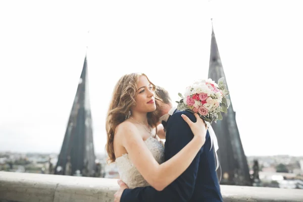 Elegante hermosa pareja de boda besándose y abrazándose en el fondo vista panorámica del casco antiguo — Foto de Stock