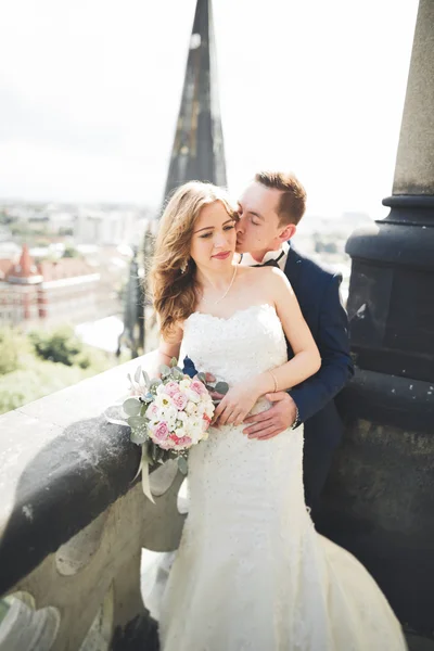 Elegante hermosa pareja de boda besándose y abrazándose en el fondo vista panorámica del casco antiguo — Foto de Stock