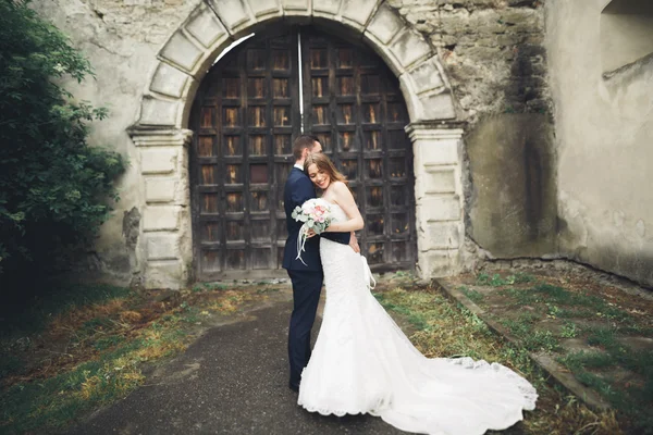 Hermosa boda romántica pareja de recién casados abrazos cerca del viejo castillo —  Fotos de Stock